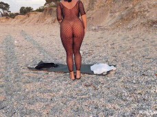 Kinky Eveline in bodystocking on beach shows off butt plug gif